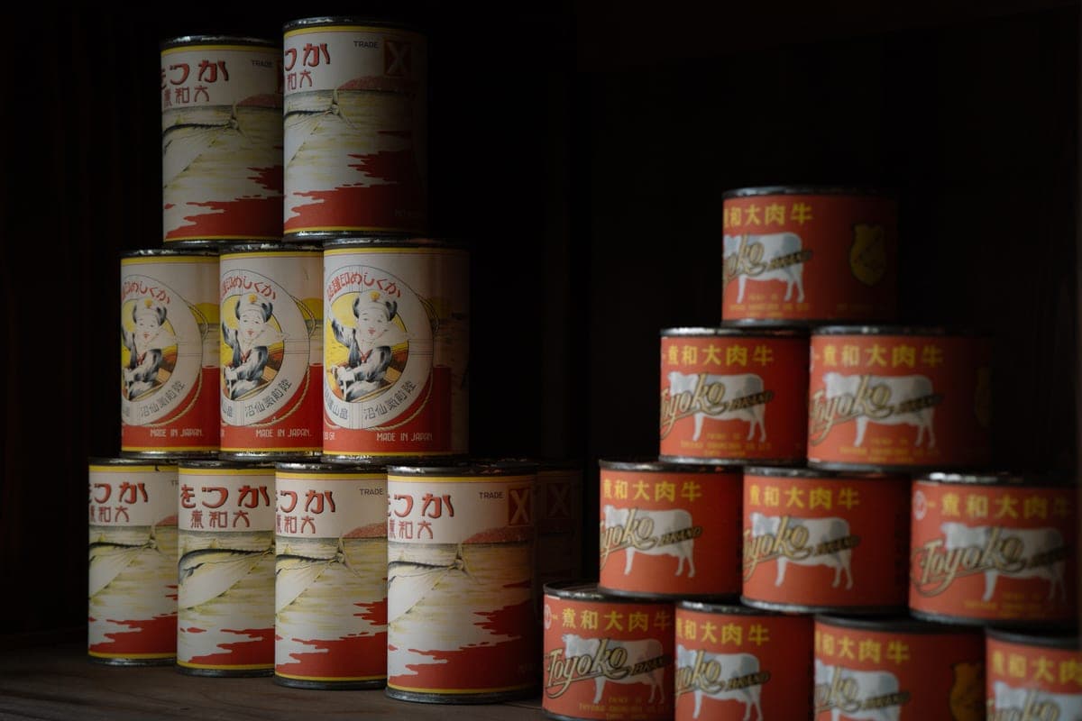 Food cans stacked on a pantry shelf