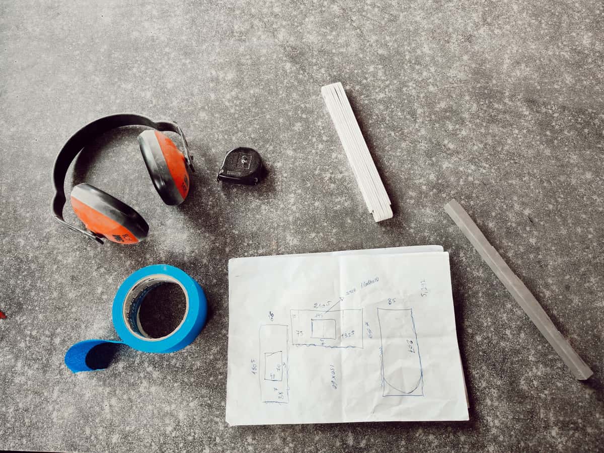 A calculator and tape measure resting on a set of plans