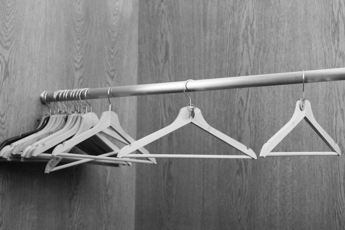 Clothes hanging from a metal closet rod