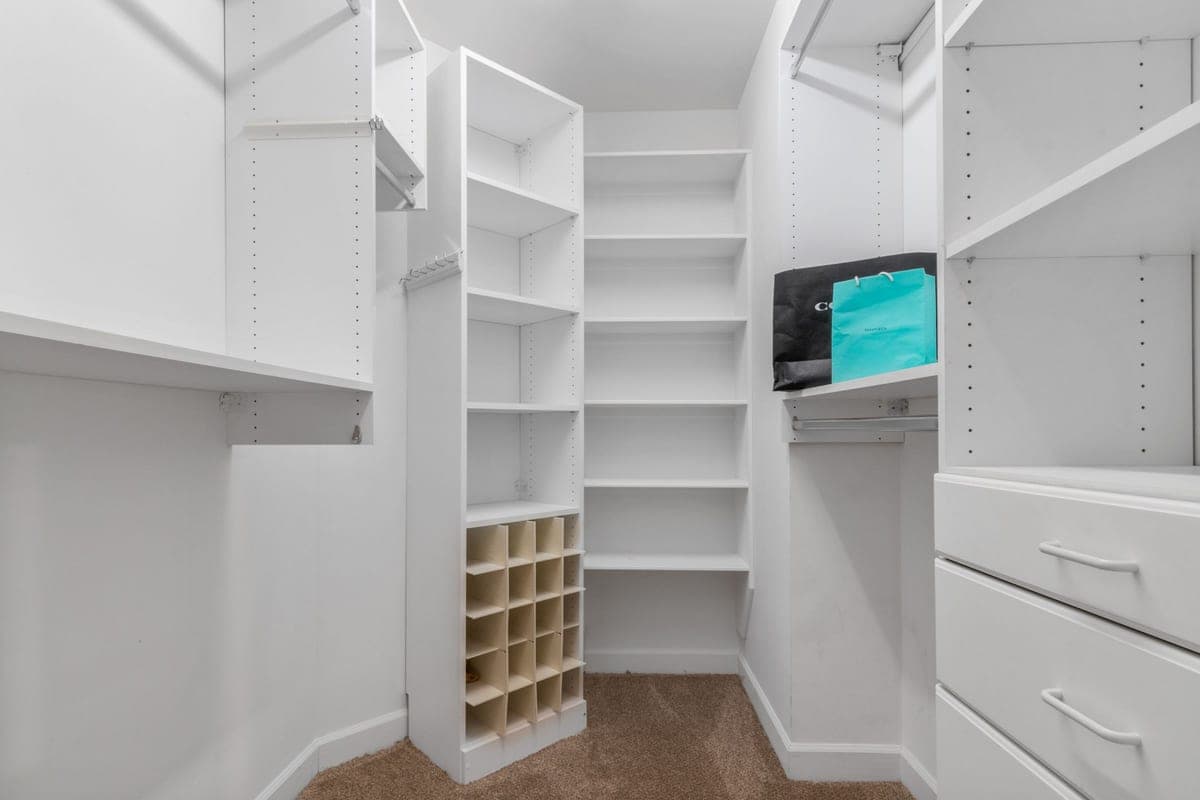 A white closet interior with shelves and drawers