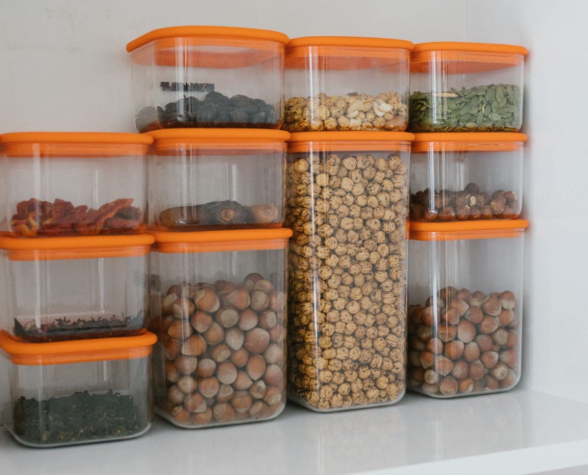 Clear plastic bins holding snacks on a pantry shelf