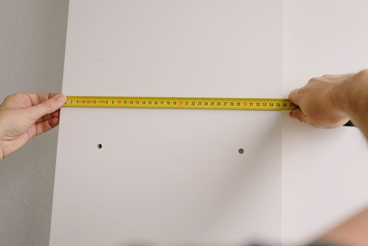 A tape measure being used to measure a shelf