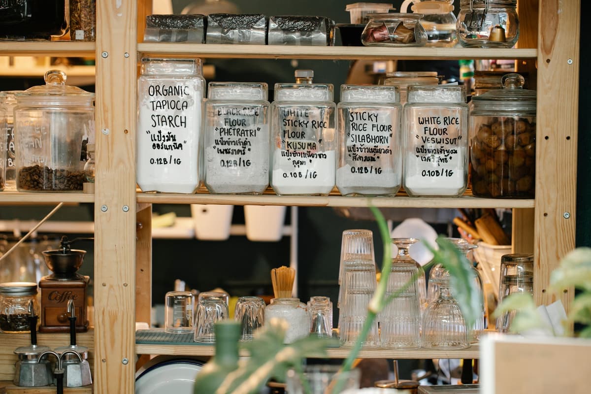 Wooden pantry shelving holding storage jars and packaged food