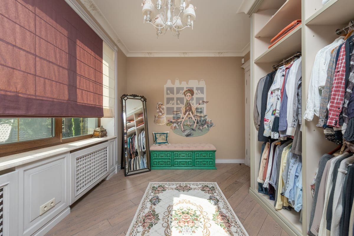 A walk-in closet with hanging rails on two walls