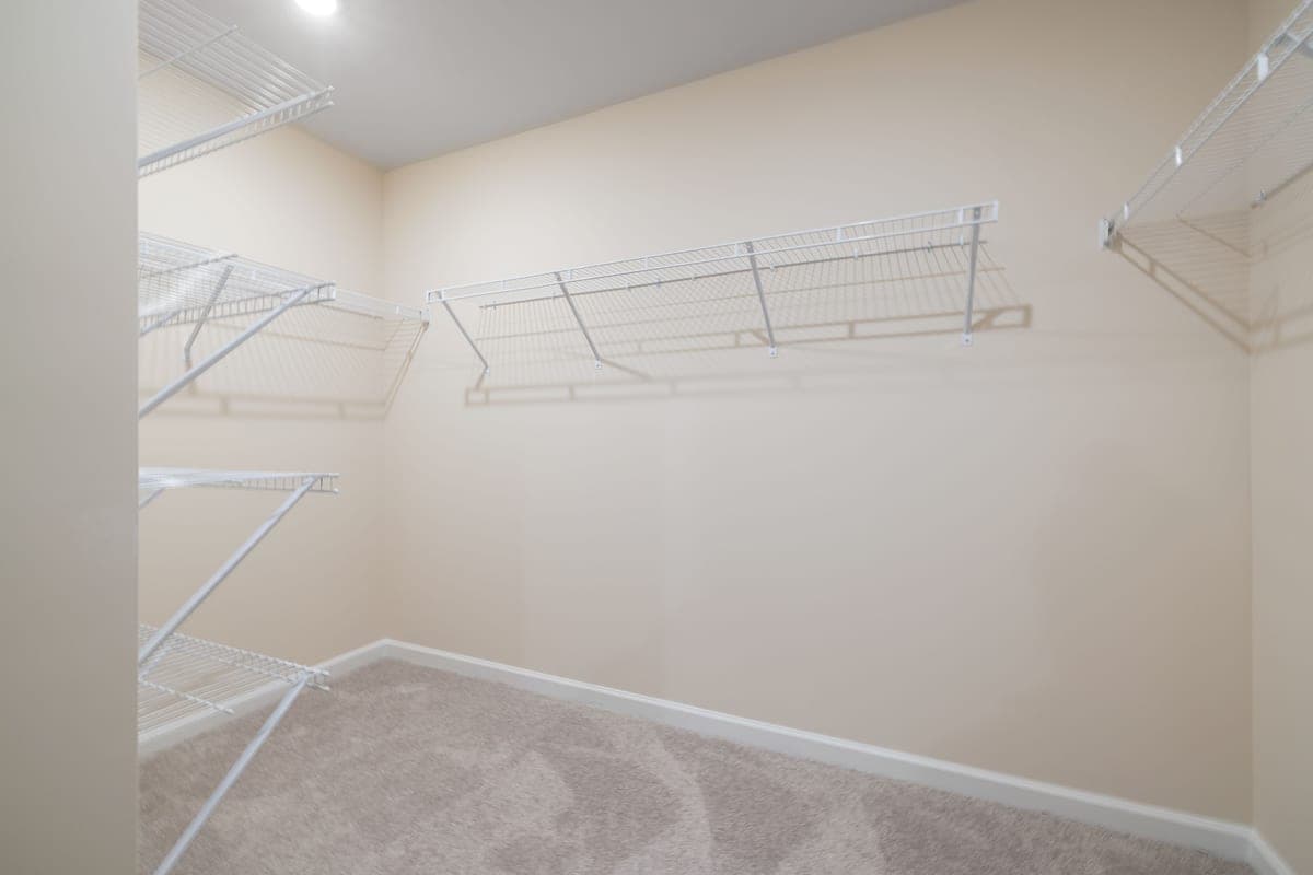 White ventilated wire shelving mounted on a closet wall